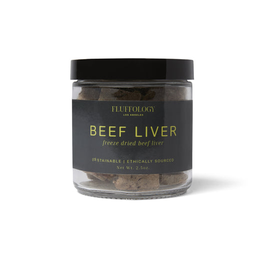 A clear glass jar containing freeze-dried beef liver dog treats, with a black label that includes the brand name 'Fluffology' and the product name 'BEEF LIVER'.